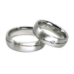 Traringe in Weißgold mit Wellennut und einem Diamanten