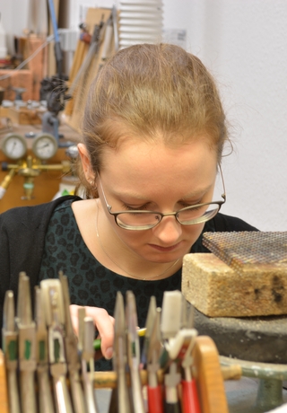 Goldschmiedin hinter Zangen bei der Arbeit Goldschmiede Albath